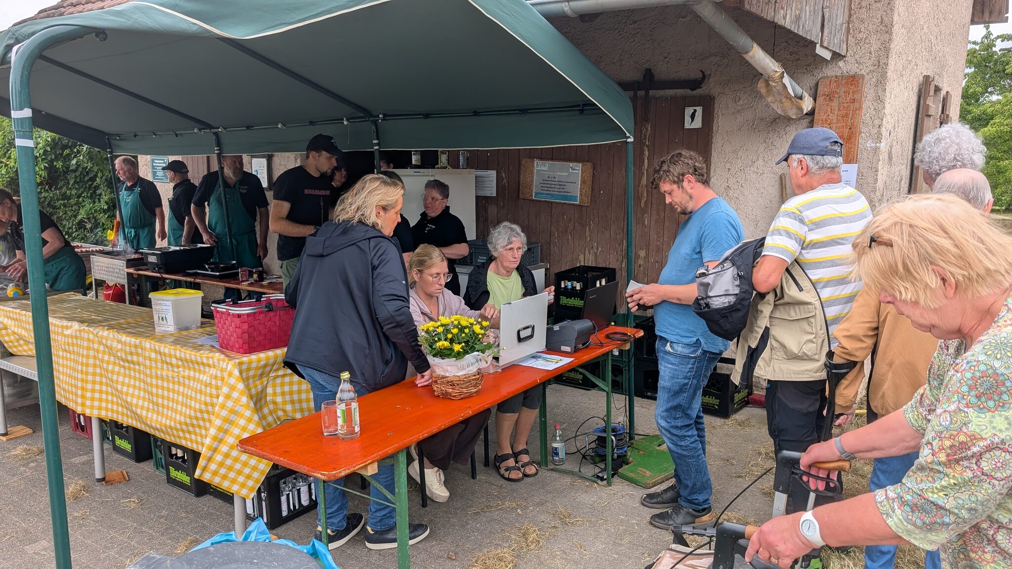 Ausgabetheke mit Helferinnen und Helfern an der Weinkanzel