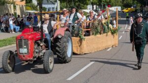 Voll besetzter Festwagen, begleitet von einem Fußjäger