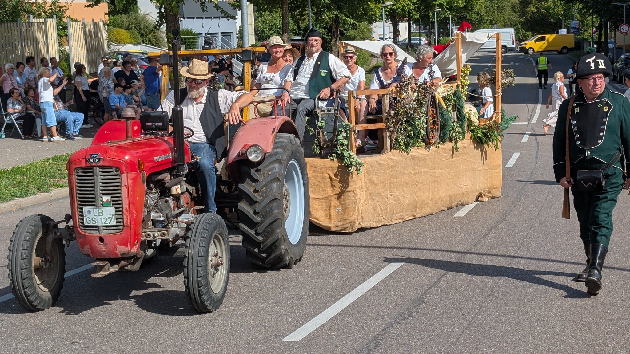 Voll besetzter Festwagen, begleitet von einem Fußjäger
