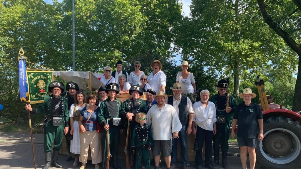 Gruppenbild der Schwarzen Jäger mit Standarte vor dem Festwagen